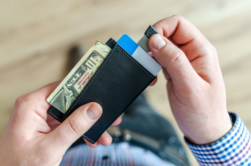 Un hombre mirando la cartera con dinero despues de haberse ahorrado dinero con ETFs de bajo costo.