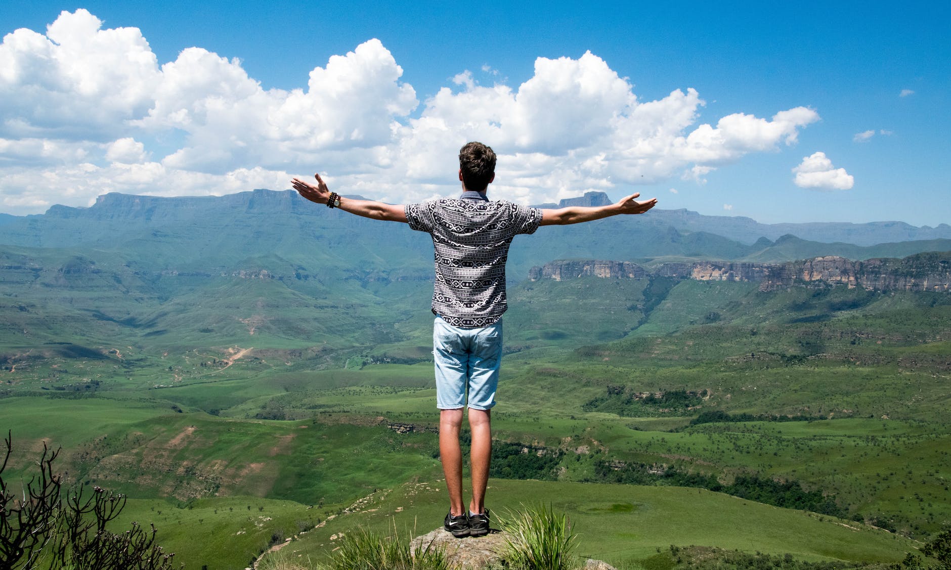 Un hombre en la cima de la montaña disfrutando porque alcanzo FIRE.